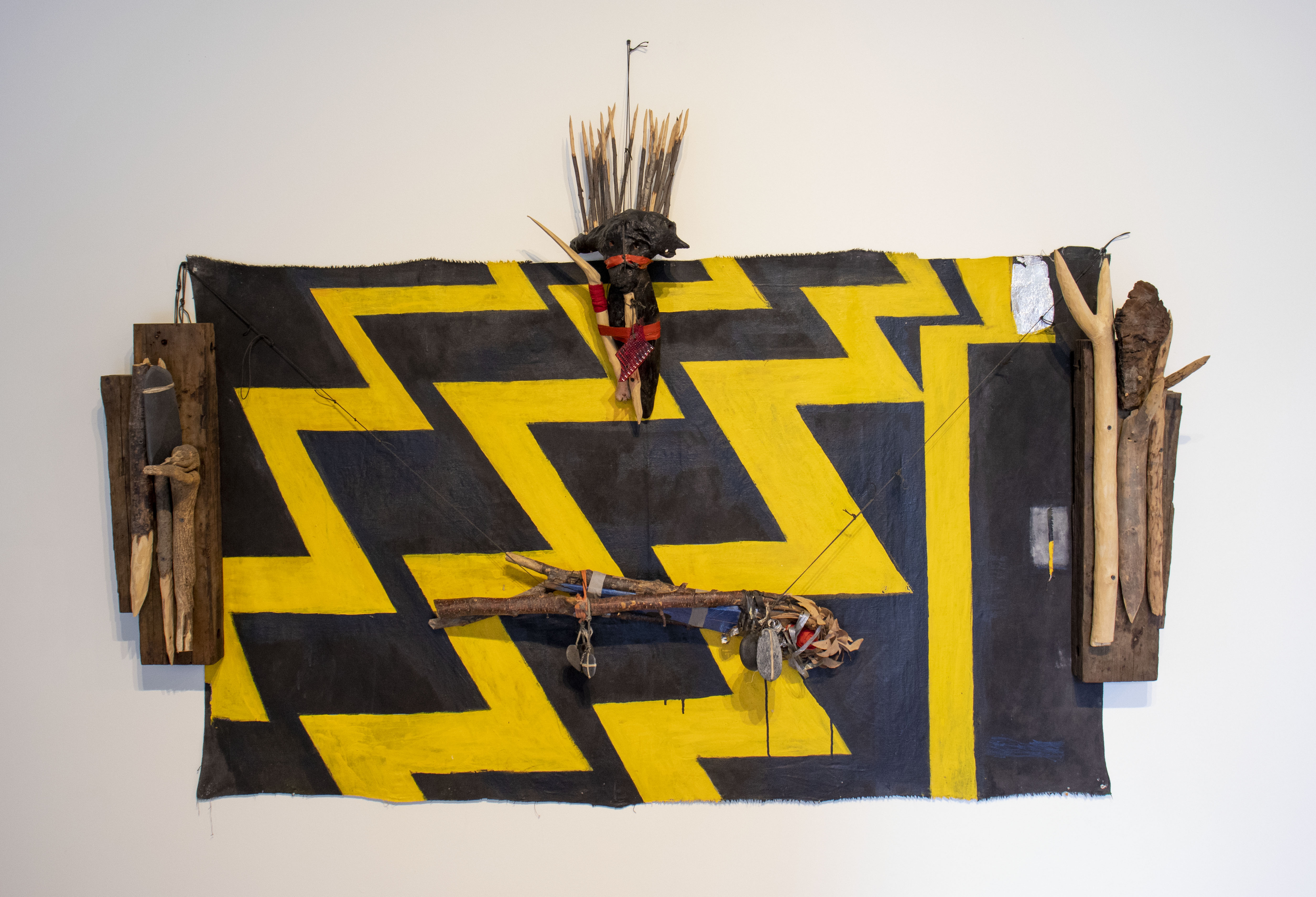 Aftershock, a black and yellow zigzag pattern with wooden carved pieces hanging over top