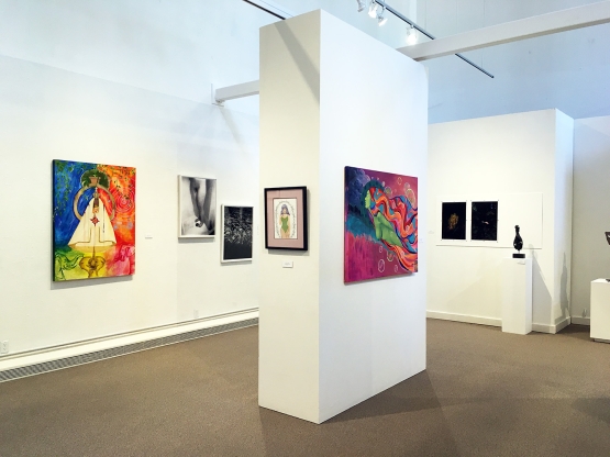 White gallery walls with colorful artwork hung on a rectangular floating wall in midframe